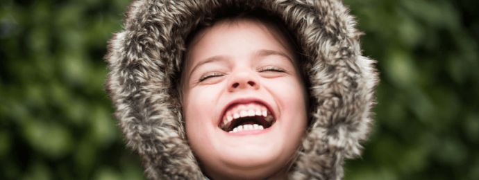 kid laughing wearing a winter coat