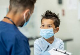 a dentist and a kid wearing masks during a dental appointment